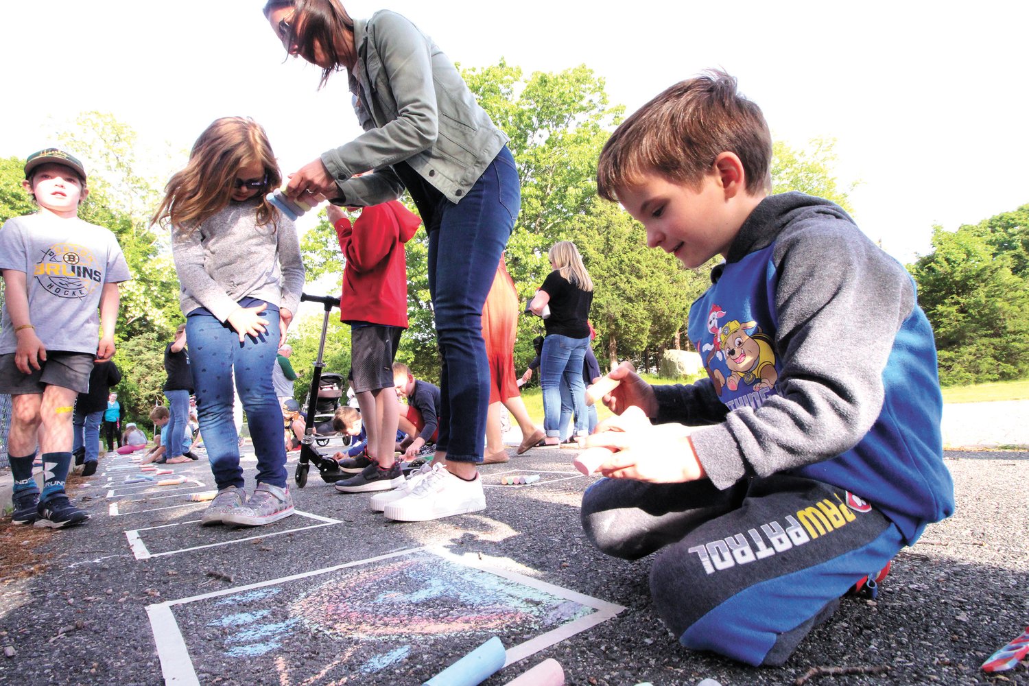 TALENT IN ACTION: As an activity of Arts Night, students registered to draw in chalk a creation of their imagination on numbered sidewalk panels with the prospect of having their work picked for prizes.  Kindergartner Lukas Heimiller took the challenge seriously, diligently applying himself to the admiration of onlookers.